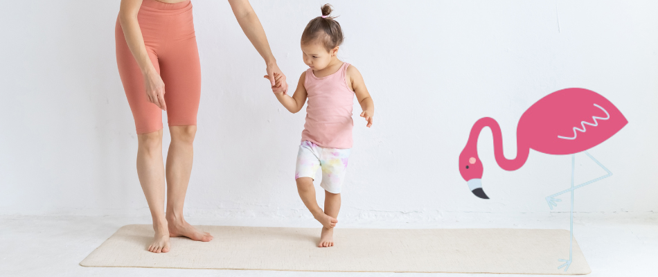 Ein Kind und eine Frau, beide in sportlicher Kleidung, üben auf einer Matte die Flamingo-Pose. Ein rosa Flamingo ist als Illustration daneben zu sehen.